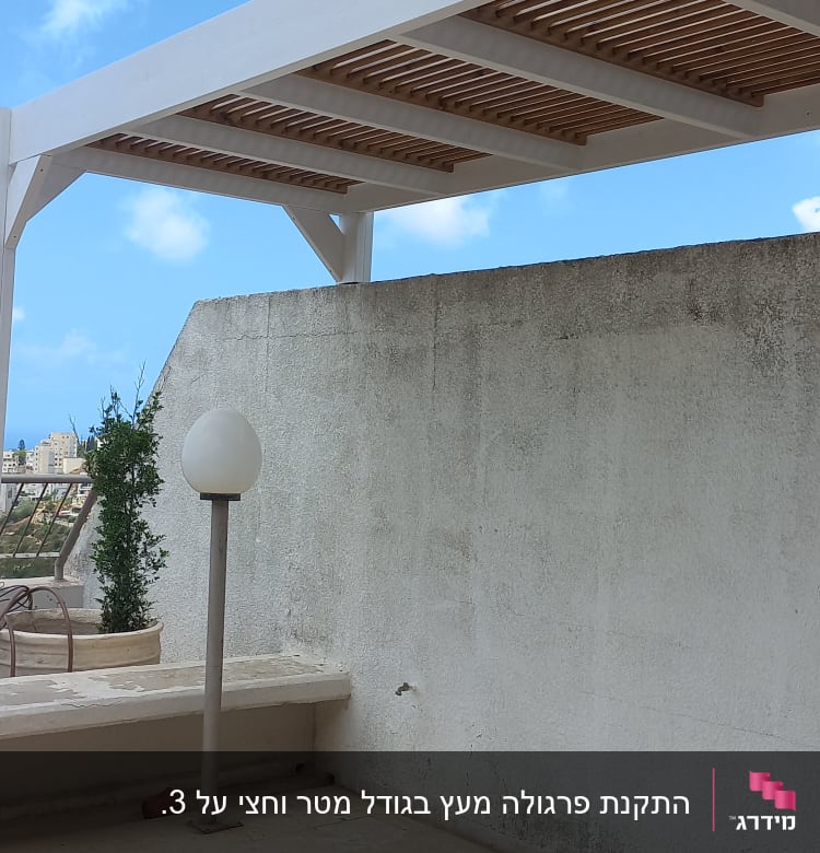 פרגולה מעץ לבן על מרפסת עם קיר לבן